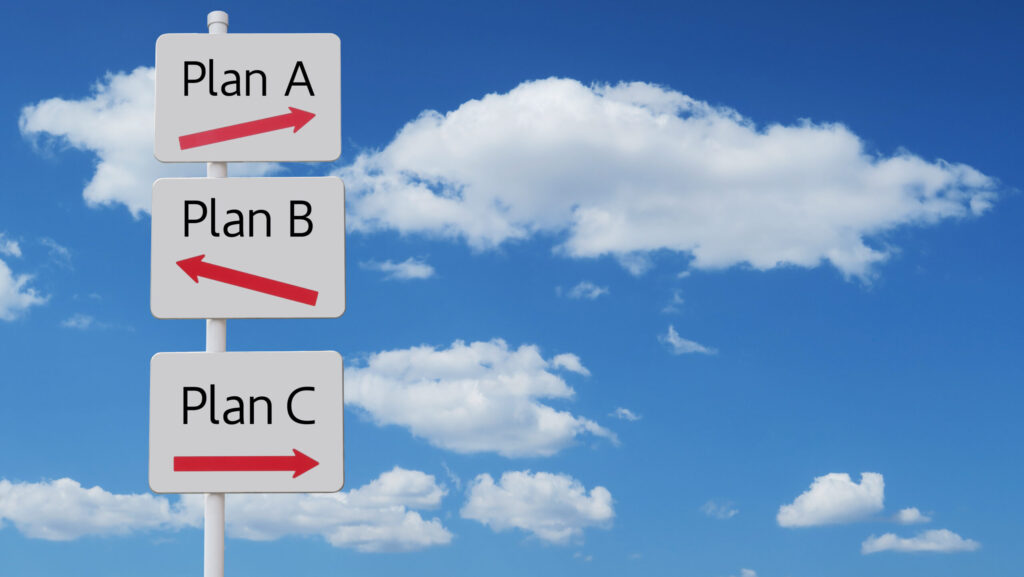 青空を背景に立てられた、Plan A、Plan B、Plan Cの選択肢と赤い矢印が描かれた白い案内標識